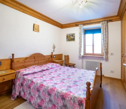 Camera matrimoniale con arredi in legno nell’appartamento Mortisa a Cortina d’Ampezzo
