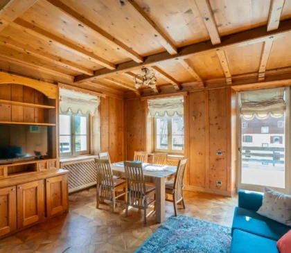 Salotto in stile rustico con travi a vista nell'appartamento in Via Faloria a Cortina