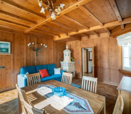 Salotto con travi in legno a Via Faloria, atmosfera rustica elegante